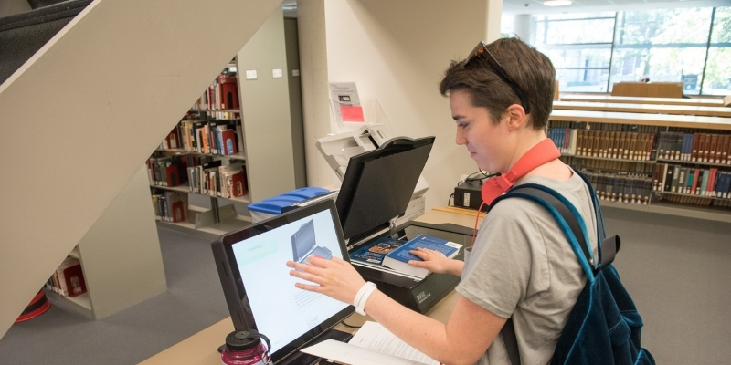 a Smith College student scanning a book with scanning equipment