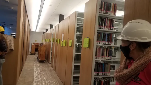mover looking down a row of bookshelves in the Neilson library