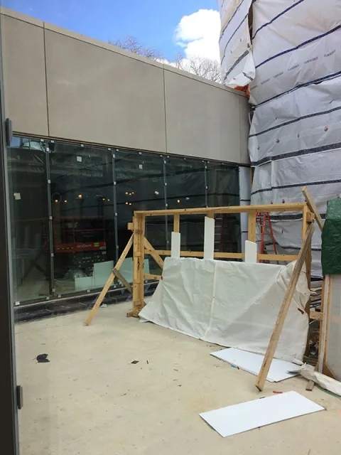 View from the sunken courtyard showing new precast concrete panels and the glass panels allowing light into the below grade spaces. This view is looking towards College Hall