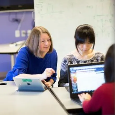 woman helping student at desk