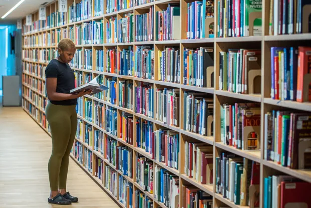 Student pulling book from shelf in Neilson Library