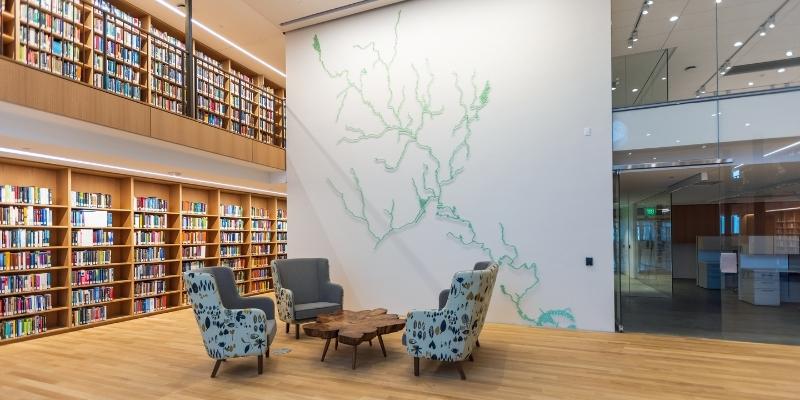 chairs with floral fabric in front of bookcases